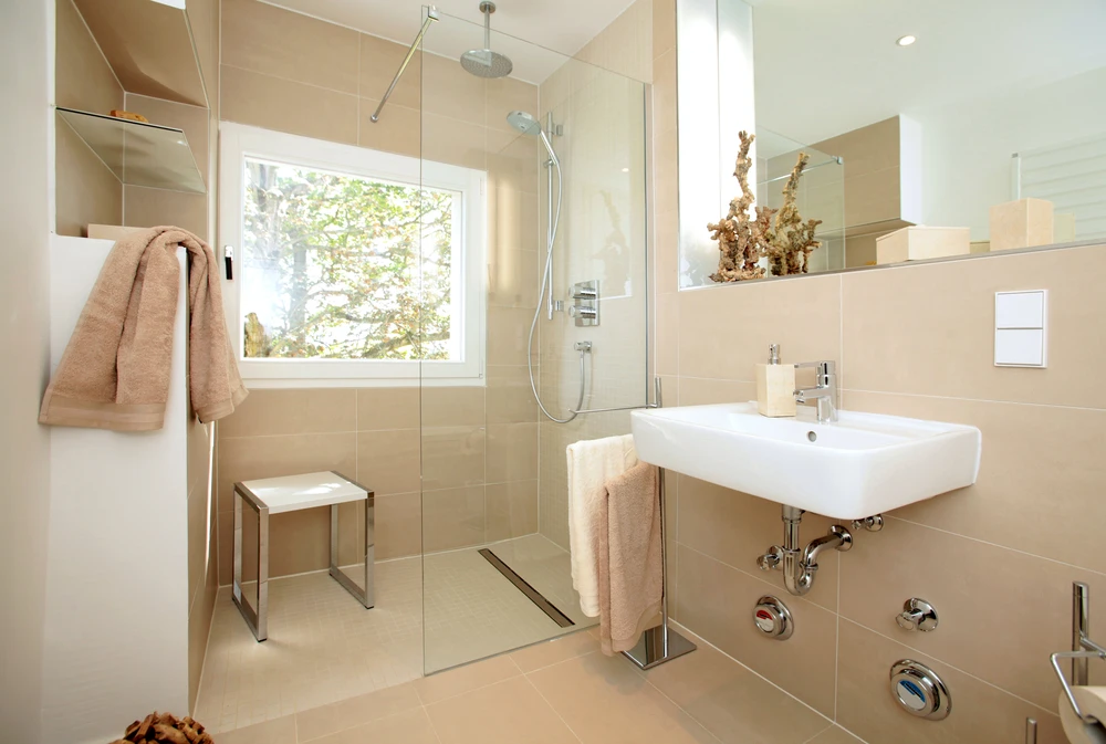Salle de bain moderne avec douche à l'italienne vitrée, lavabo suspendu blanc, robinetterie chromée contemporaine